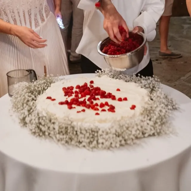 Mirii decorează Pavlova cu zmeură în fața invitaților